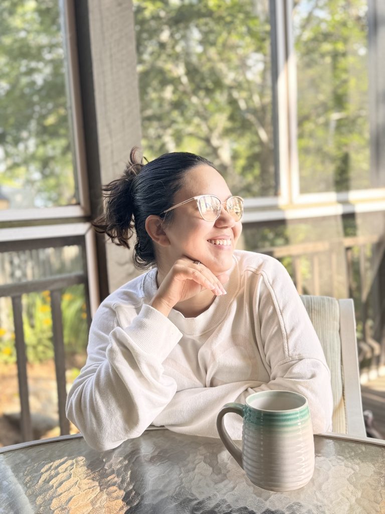 Dannette enjoying coffee by a sunny window